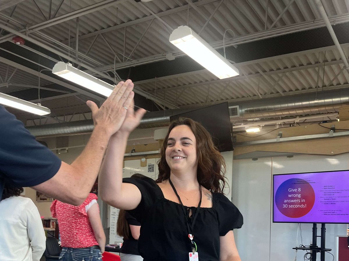 A participant high-fives another after a chaos-game round, smiling broadly.
